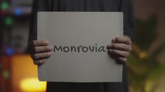 Monrovia written on Banner &ndash; Man Holding Placard