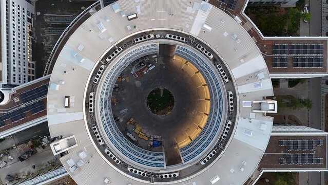 Aerial view of the circular Keppel Data Center Reit building complex featuring a central courtyard, rooftop solar panels, and HVAC units in Offenbach am Main, Hessen, Germany.
