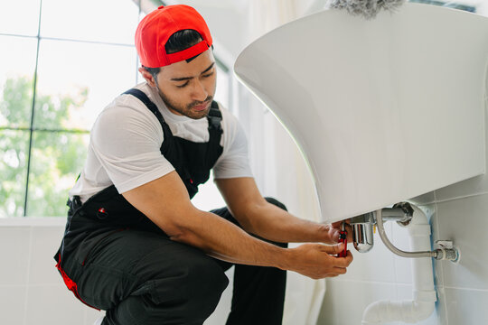 Professional Plumber Fixing Sink Pipe in Modern Bathroom for Residential Maintenance Services