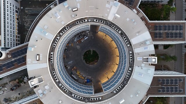 Aerial view of the circular Keppel Data Center Reit building with a central courtyard, rooftop solar panels, and modern architecture in Offenbach am Main, Hessen, Germany.