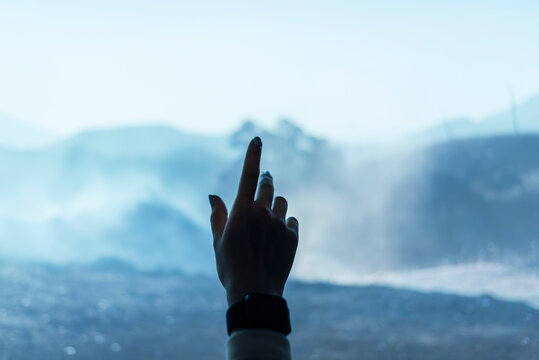 Hand reaching in the air, ocean view