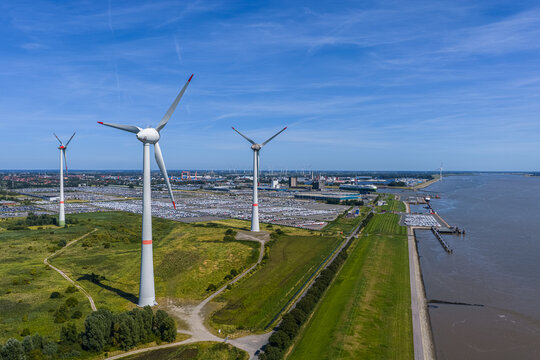 Aerial view of the Volkswagenwerk Emden factory with wind turbines, industrial infrastructure, and the Ems river in Emden, Niedersachsen, Germany.