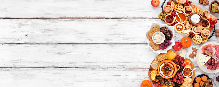 Autumn or Thanksgiving appetizers, sweets and grazing boards. Top view side border on a white wood banner background. Pumpkin and apple snacks, charcuterie, pies, desserts.