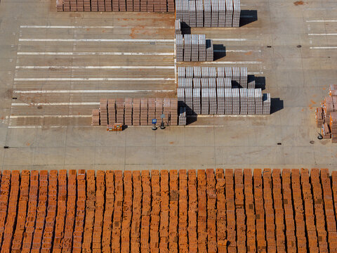 Aerial view of organized stacks of construction bricks in an industrial storage yard in Konin, Wielkopolskie, Poland.