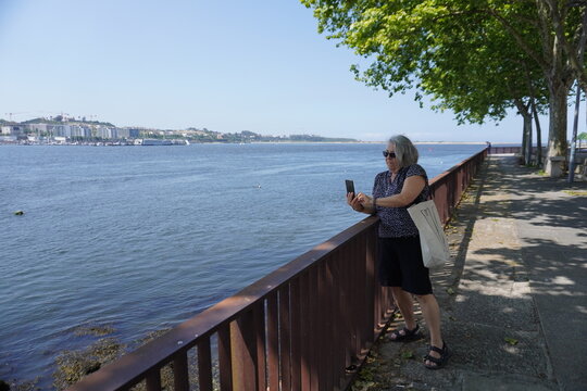 Senior woman taking a picture with her phone on vacation