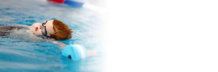 Fototapeta premium A boy in the pool will follow his coach. The child learns to swim crawl. a web banner with space for text and space for copying