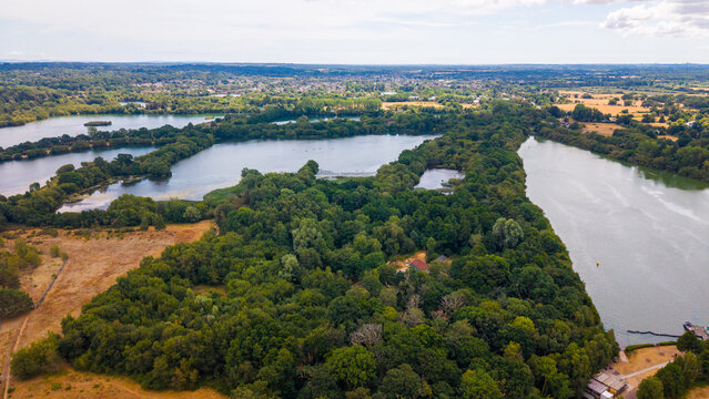 Aerial view of Bashford Lakes Nature Reserve featuring interconnected lakes, dense woodland, and freshwater habitats in the English countryside near Ringwood, Hampshire, United Kingdom.