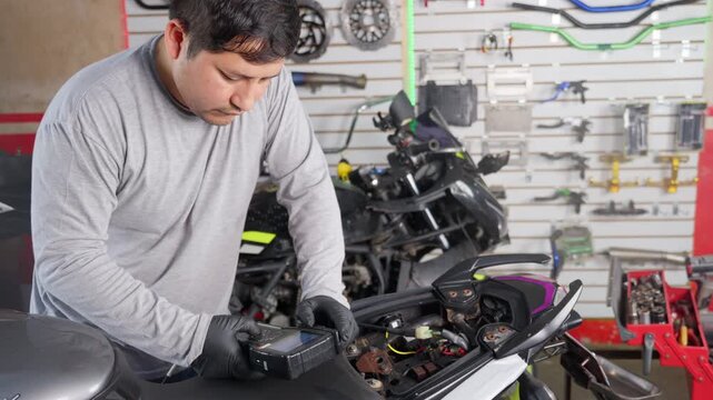 Mechanic performing diagnostic scan on motorcycle engine