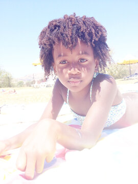 Close-up of a young Girl in a bikini  lying on her front on a sandy beach
