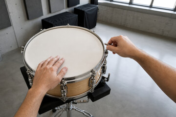 Obraz premium Drum Technician Hands Tensioning Snare Drum Head with Copy Space