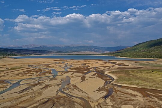 Aerial view of Twin Lakes with intricate river delta patterns and surrounding mountains under a blue sky in Twin Lakes, Colorado, United States.