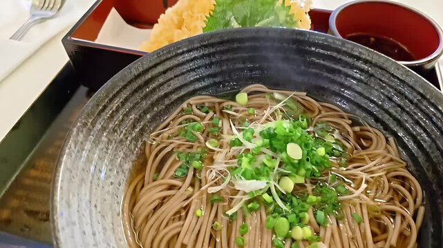 Bowl of soba buckwheat noodles with Ebi shrimp tempura, Japanese Food Cuisine, Healthy Meal, Scallion Garnish, Panning Shot