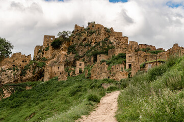 Fototapeta premium Deserted mountain settlement rests among rugged peaks and wild greenery