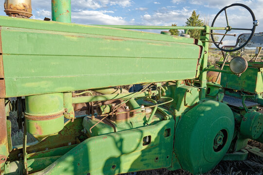 An abandoned farm tractor is rusting in the field