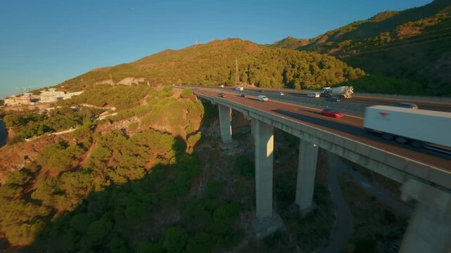 FPV-Drohnenflug parallel zur Autobahn nahe M&aacute;laga mit anschlie&szlig;endem Tiefflug &uuml;ber eine Talkante und Aufstieg aufs Meer bei Sonnenaufgang