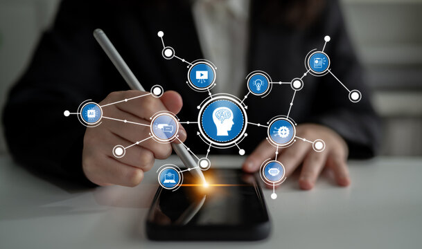 A business professional engages with a smartphone, surrounded by a creative mind map of digital icons, symbolizing innovation and technology in a modern workspace. Tessel