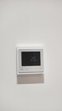 white thermostat for underfloor heating and climate control systems. control panel. apartment, house, hotel. smart home. automatic heating system. technology. stylish designer expensive repair