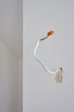 Electrical cable with exposed colored wires and terminal connector extends from wall