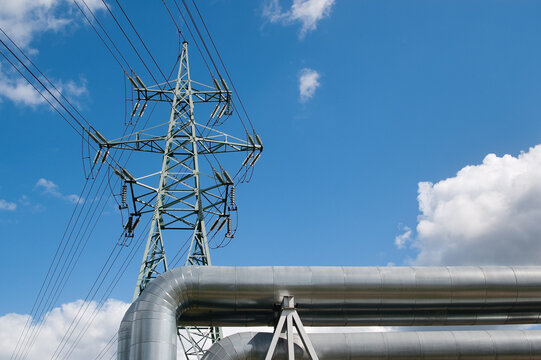 a pipeline and a power transmission tower against a blue sky