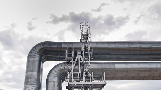 The photo shows a pipeline against a gray sk