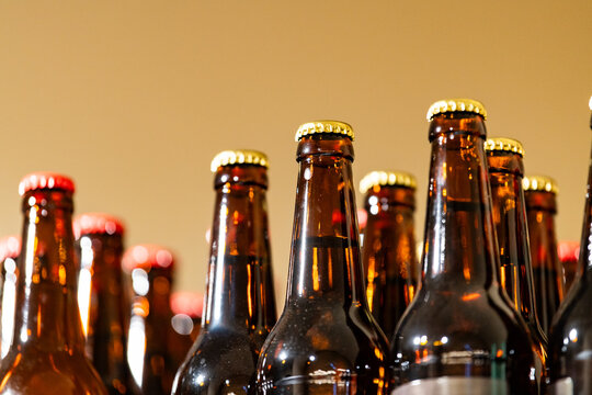 Close up of assorted beer bottles with metal caps. Alcohol beverage collection and brewery production concept with copy space