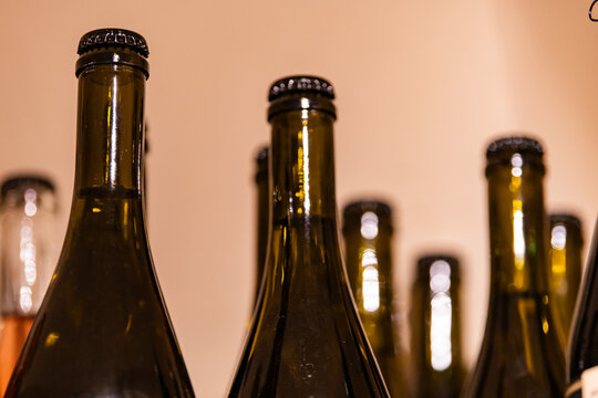 Close-up of brown glass bottles with metal caps. Beverage packaging and bottling industry concept with shallow depth of field