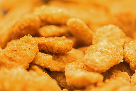 Close up of crispy breaded chicken nugget with golden crust. Fast food snack and comfort meal concept for menu design, food advertising, restaurant promotion