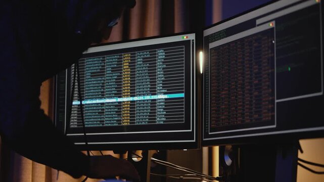 Technology specialist reviews active development workflows on multiple screens, representing continuous integration, cloud infrastructure, automated deployment, system monitoring, reliable software.