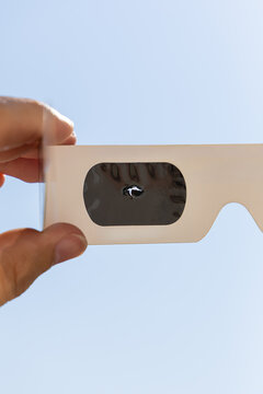 Une paire de lunettes d&rsquo;&eacute;clipse solaire avec un trou, inutilisable et dangereux pour les yeux. Le format est vertical.