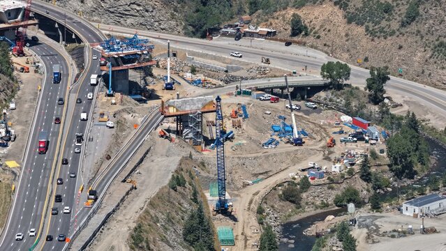 Aerial view of the highway construction site at Floyd Hill featuring cranes, heavy machinery, and ongoing bridge work alongside the active interstate in Floyd Hill, Colorado, United States.
