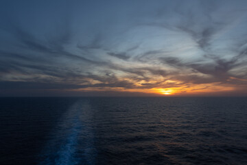 Obraz premium Sonnenuntergang von dem Heck mit dem Kielwasser eines Schiffes