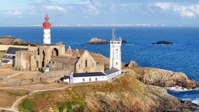 Aerial view of the Pointe Saint-Mathieu lighthouse and the ruins of the abbey on the rugged coastline of the Atlantic Ocean in Plougonvelin, Brittany, France.