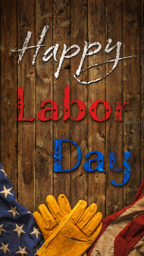Patriotic Happy Labor Day text with worn work gloves and the USA flag on wooden background. Symbolic of the American labor movement and pride in America's blue collar workers. Celebrate US Labor Day.
