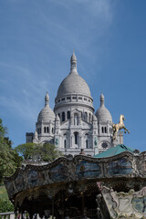 Fototapeta premium Spring day in Montmartre with cobblestone streets, whitewashed historic houses, and Sacré-Cœur Basilica towering overhead. Parisian artistic neighborhood, France