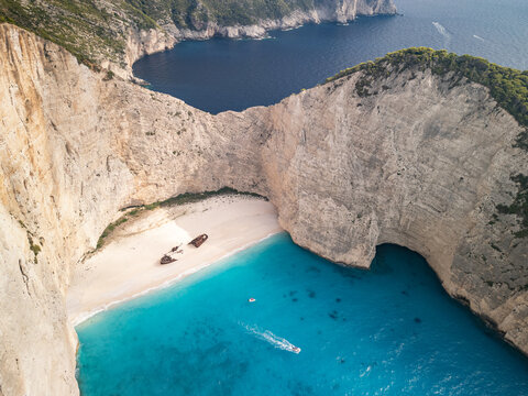 Aerial drone view of Navagio Beach, also known as Shipwreck Beach, in Zakynthos, Greece, with the MV Panagiotis shipwreck surrounded by white cliffs and turquoise waters.