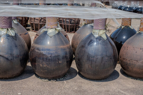 Sunbaked sweet Banyuls fortified wine in traditional demijohns bonbonnes glass jars, Roussillon, French Catalonia, Grenache and Muscat grapes, oxidative sun aging