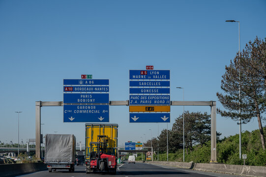 View of a French and European autoroute with overhead directional signs pointing to major cities like Paris, Bordeaux, Lille, Calais, showing lanes, traffic and motorway infrastructure, road signes