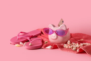 Fototapeta premium Pink piggy bank with sunglasses and euro banknote, summer vacation savings with flip-flops and seashells