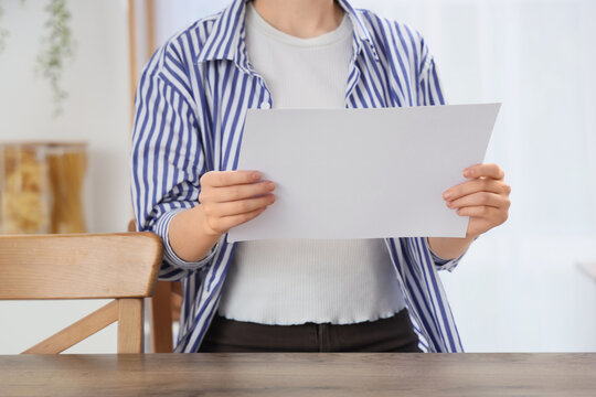 Person holding a blank white paper sheet with copy space, document and information concept, communication and message