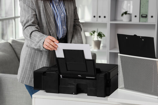 Businesswoman using modern printer in office