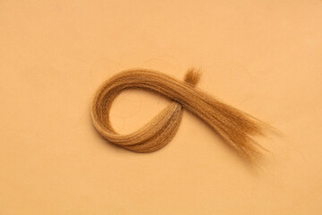 Naklejka premium Red hair strand for donation on orange background