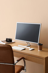 Fototapeta premium Stylish workplace with modern computer and cup of coffee near color wall