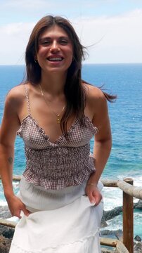 Happy young woman dancing on a beautiful coastal viewpoint