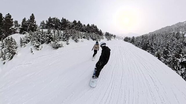 Couple snowboarding and holding hands on a mountain slope
