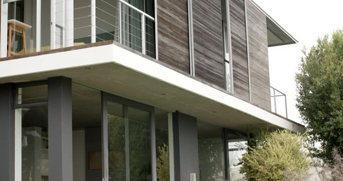 Camera is panning up from porch to balcony while facade is revealing wooden slats, showing design