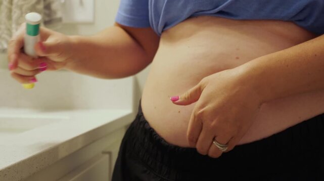 Woman giving herself auto-injector injection in abdomen for biologic allergy therapy, GLP-1 weight loss medication, or chronic medical treatment