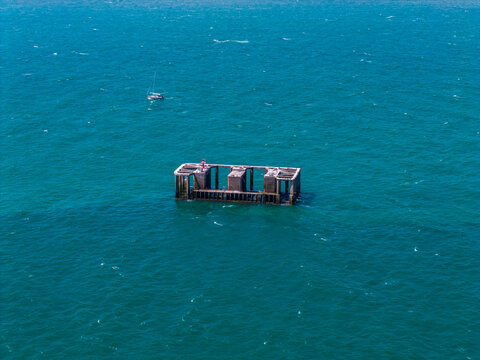 Aerial view of a historic concrete blockhouse bunker from World War II standing in the sea near the coast of Boulogne-sur-Mer, Hauts-de-France, France.