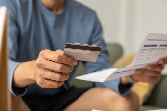 Hand credit card bill payment finance document person home holding expense hand holding credit card and bill for payment finance, reviewing document home with focused expense management