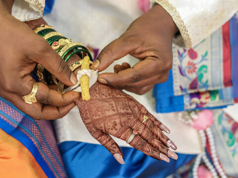 Groom Tying Haldi Kankan on Bride's Wrist during Maharashtrian Wedding Ritual