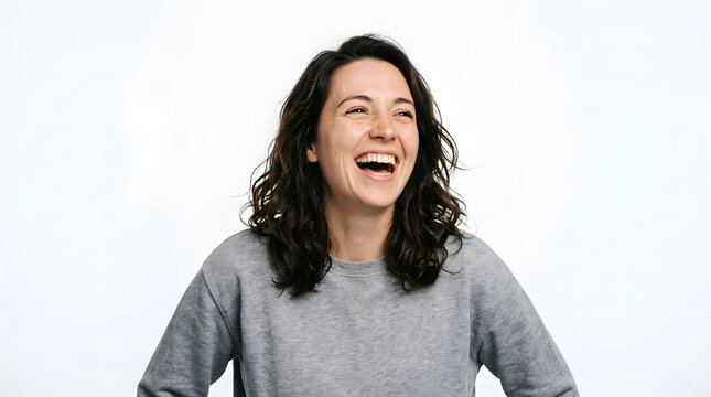 Portrait of a cheerful young woman laughing genuinely with determination and positive energy